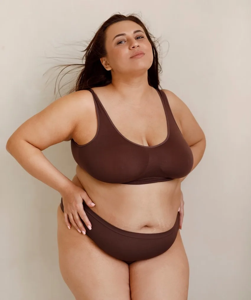 Femme ronde ou avec des belles rondeurs en lingerie deux pièces. Elle a des hanches larges un gros ventre et une grosse paires de seins lourds