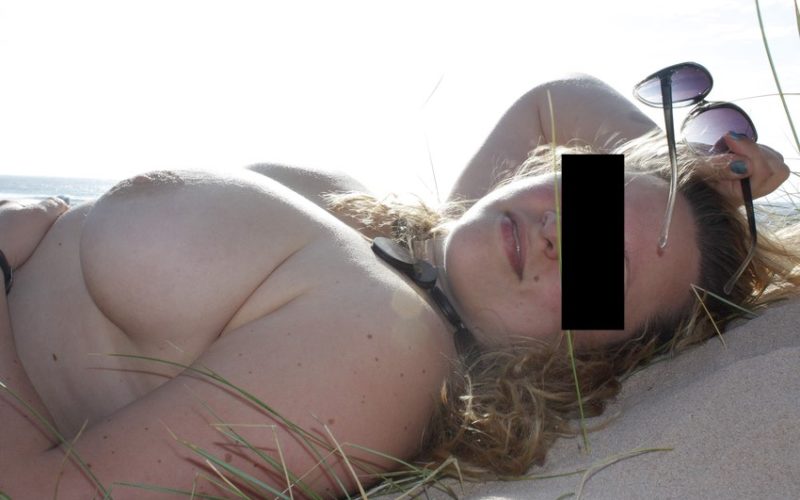 La belle et forte poitrine d'une jolie femme ronde nue sur le sable de la plage à Royan